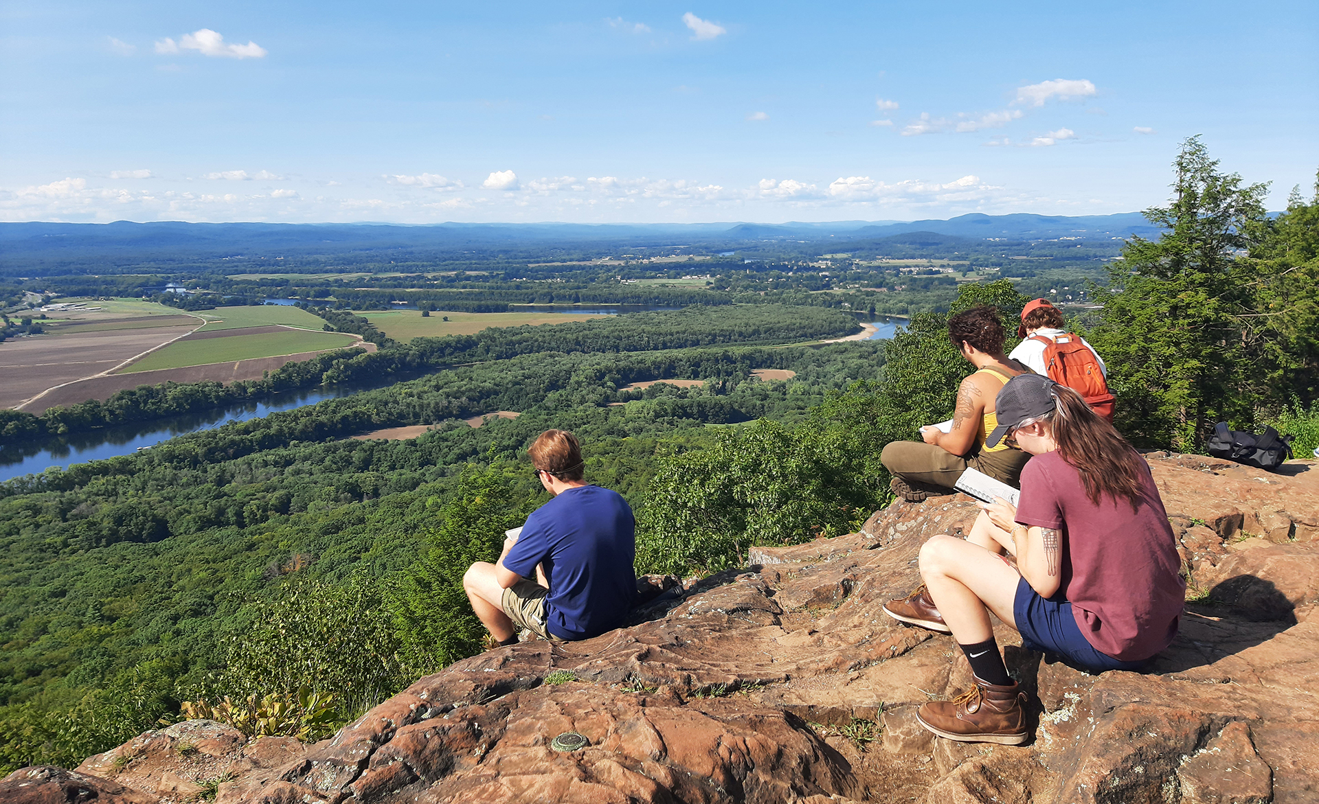 People on a ledge overlooking a valley